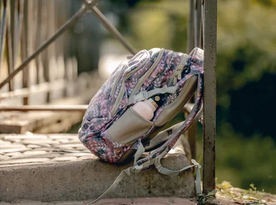 Floral Backpack Resting On A Stone Bridge