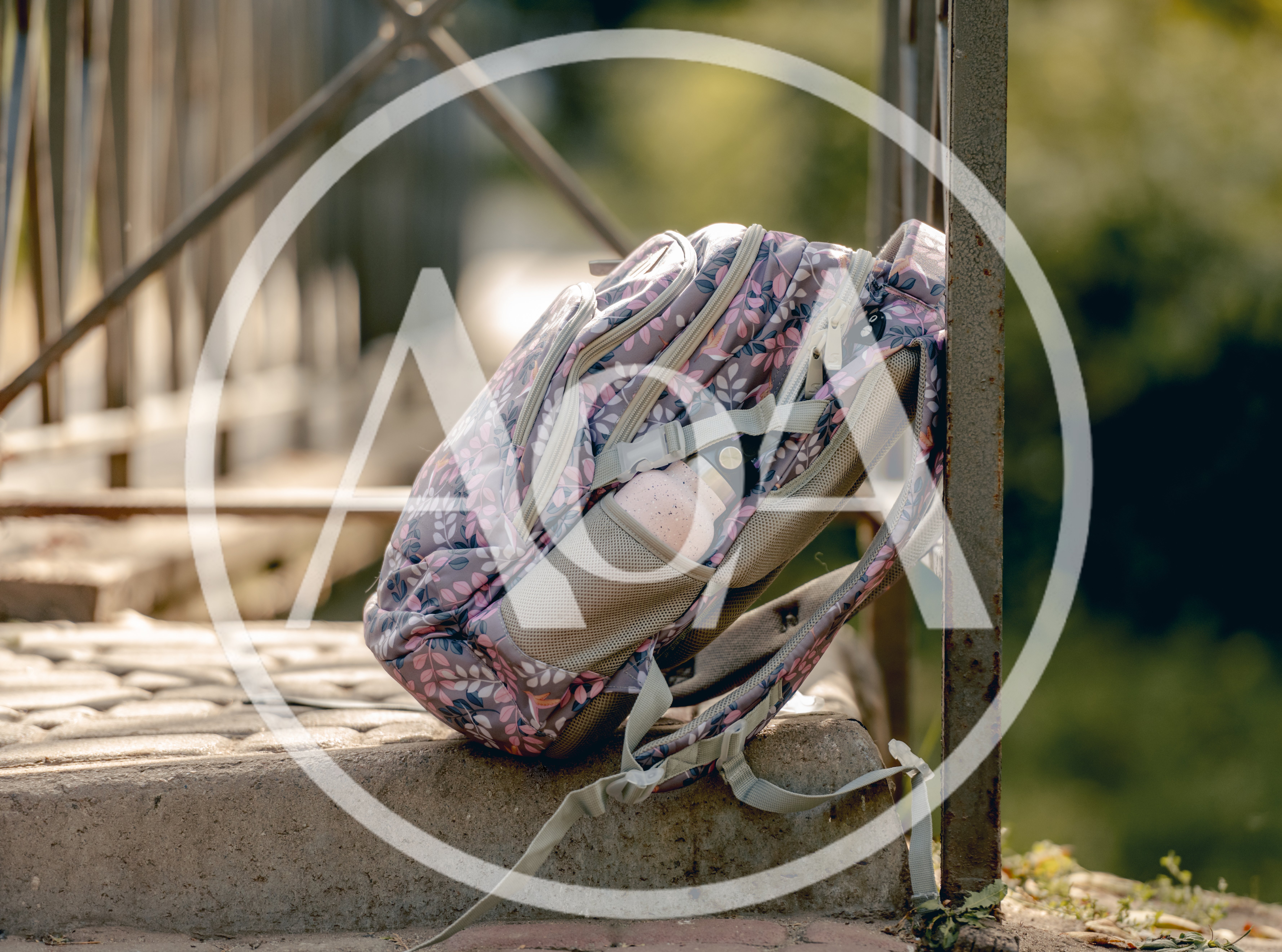 Floral Backpack Resting On A Stone Bridge