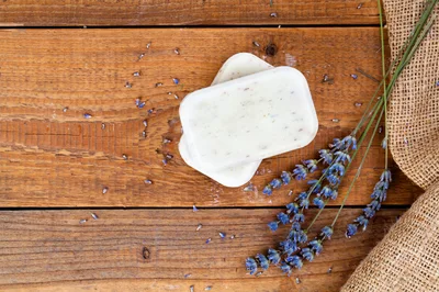 Two Bars Of Lavender Soap On Rustic Wooden Table