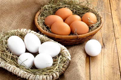 Fresh Brown And White Eggs In Woven Baskets