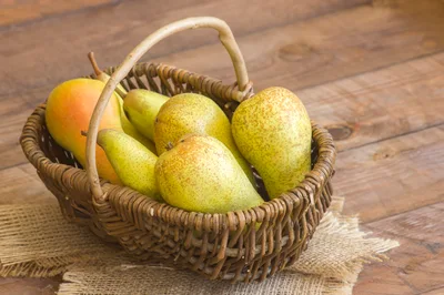 Fresh Pears In A Wicker Basket On Wooden Table