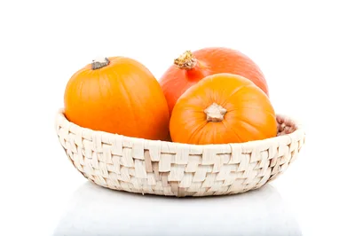 Three Fresh Orange Pumpkins In A Woven Basket