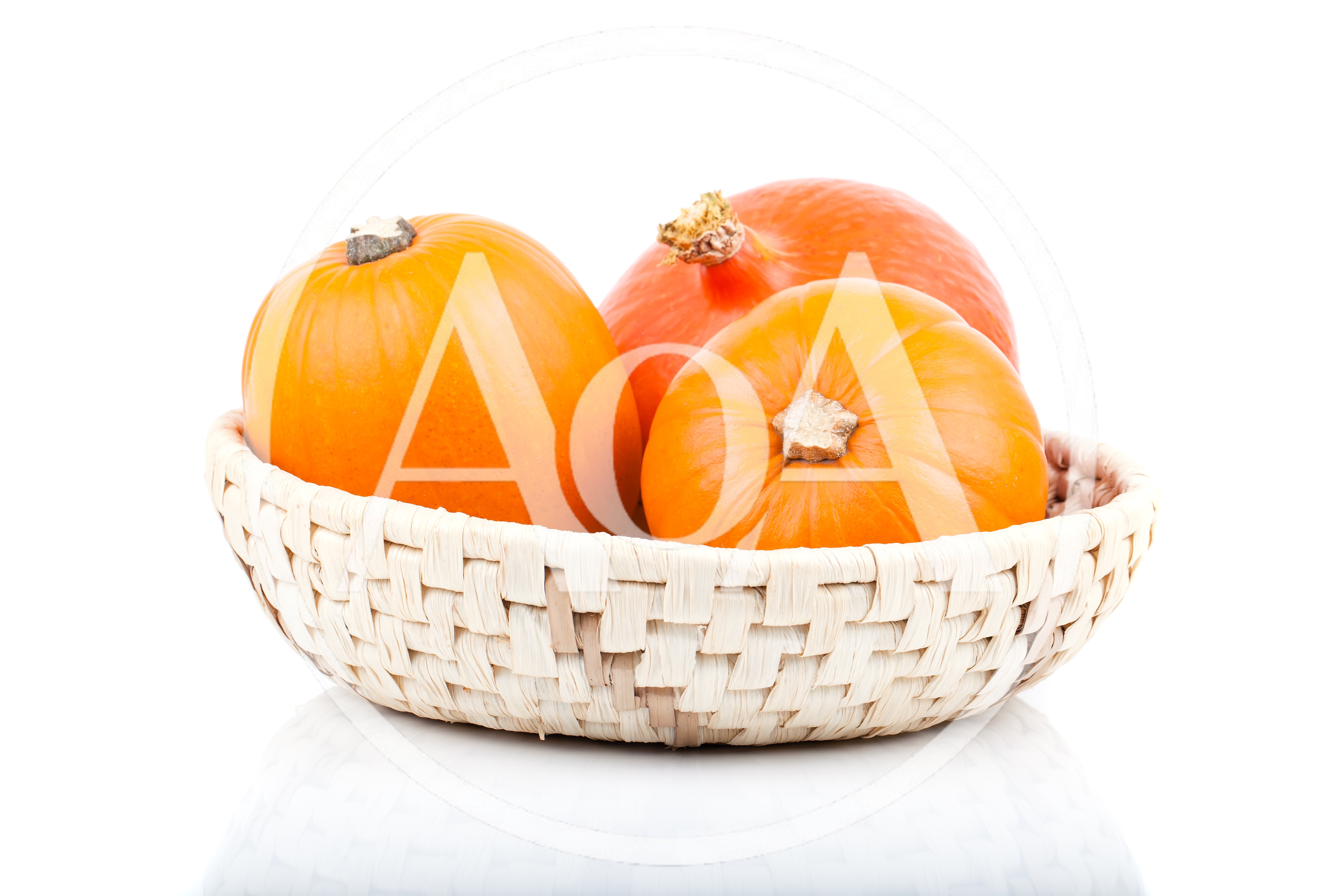 Three Fresh Orange Pumpkins In A Woven Basket