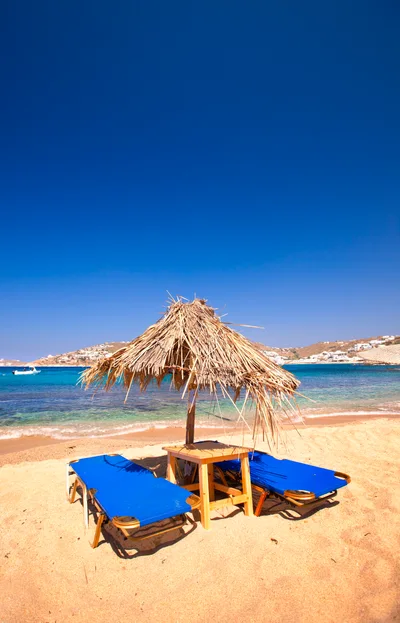 Straw Beach Umbrella With Blue Sun Loungers