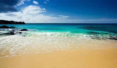 Tropical Beach Shoreline With Turquoise Water And Volcanic Rocks