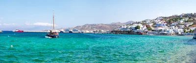 Panoramic View Of Mykonos Harbor With Traditional Boat