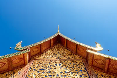 Ornate Thai Temple Roof Against Clear Blue Sky