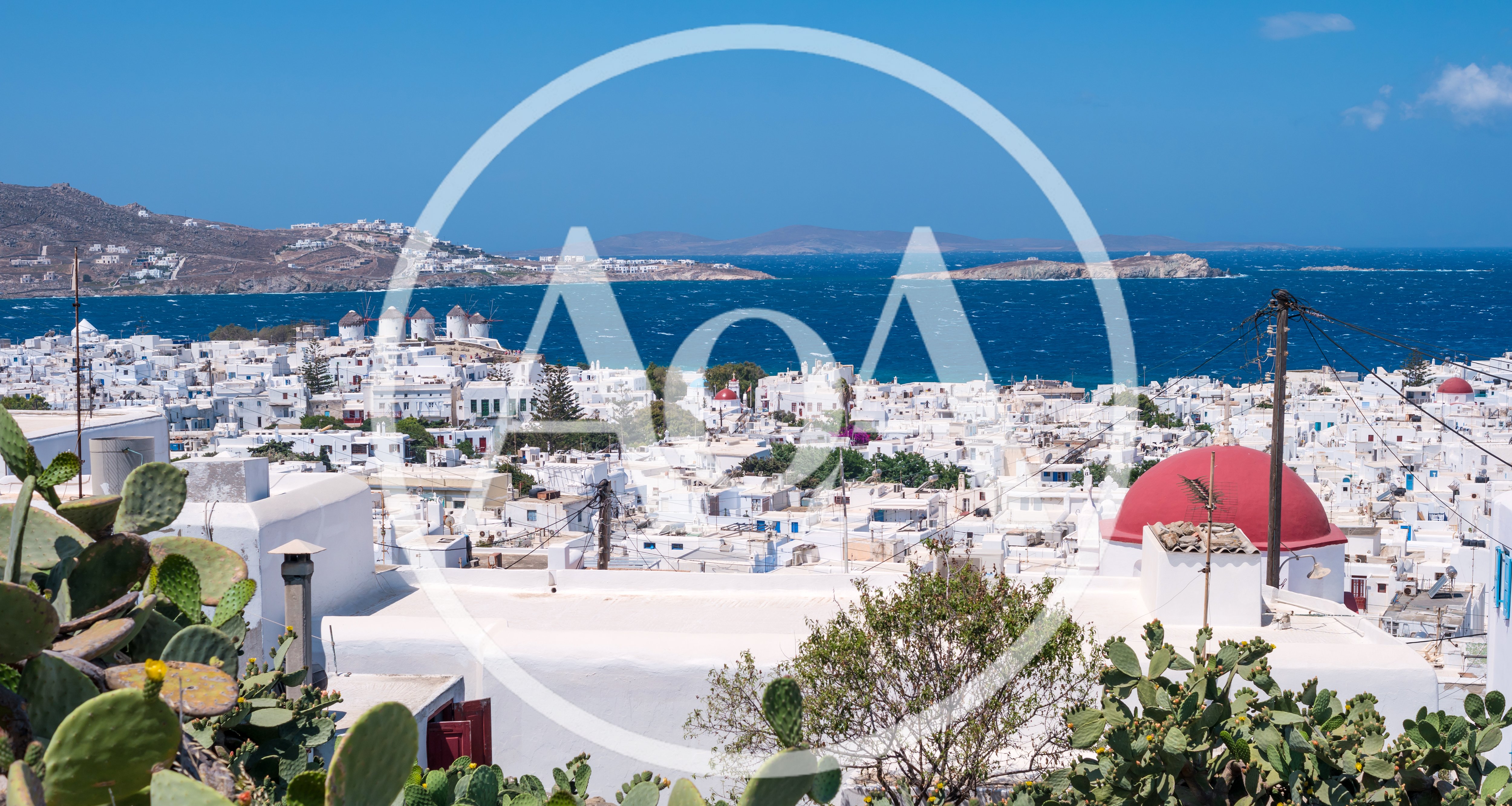 Panoramic View Of Mykonos Town With Iconic Windmills