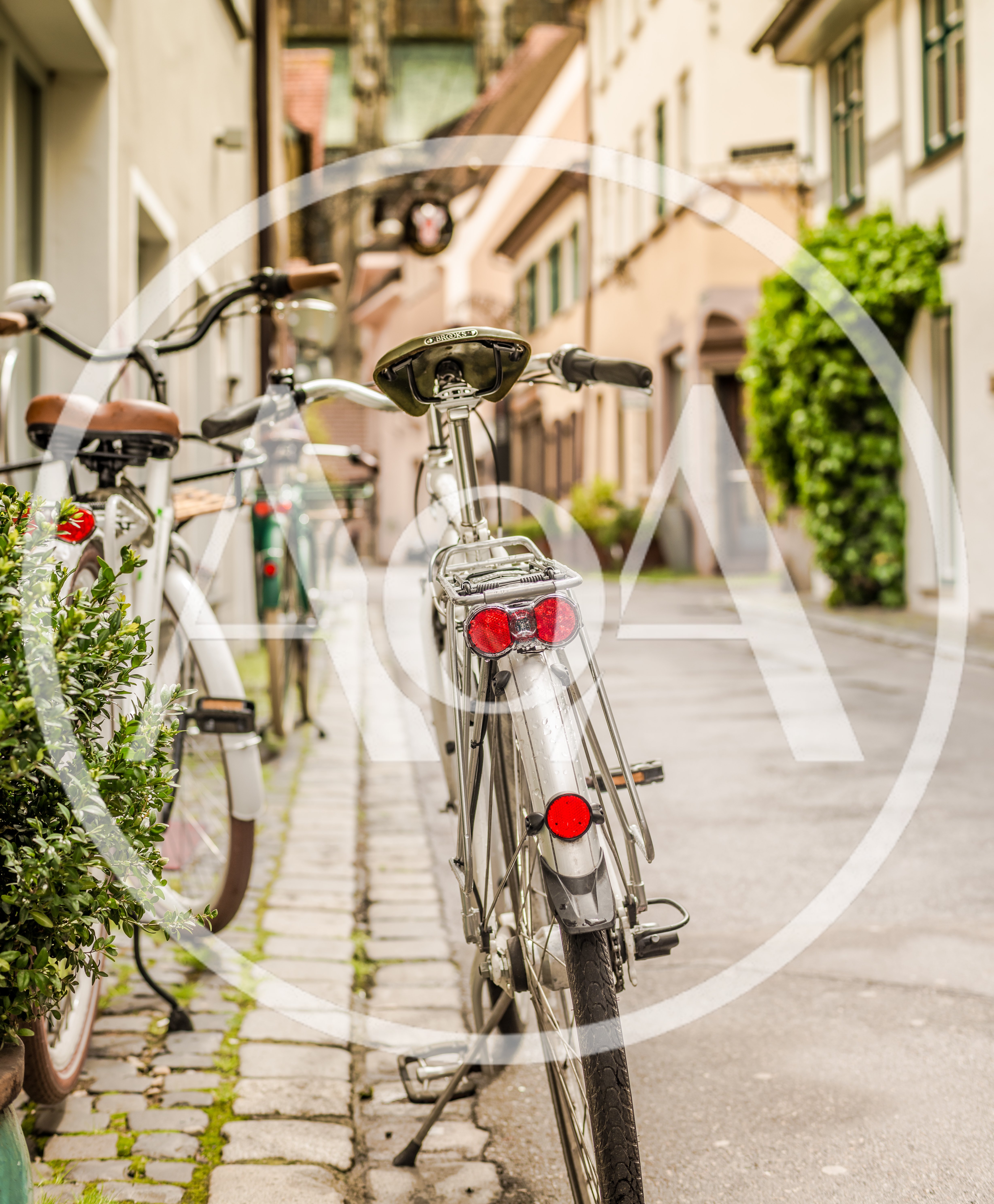 Bicycles Parked On A Cobblestone Street In A European Town