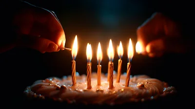 Hands Lighting Birthday Candles On A Cake