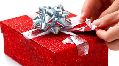 Hands Wrapping A Glittery Red Gift Box