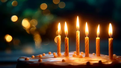 Six Lit Birthday Candles On A Frosted Cake