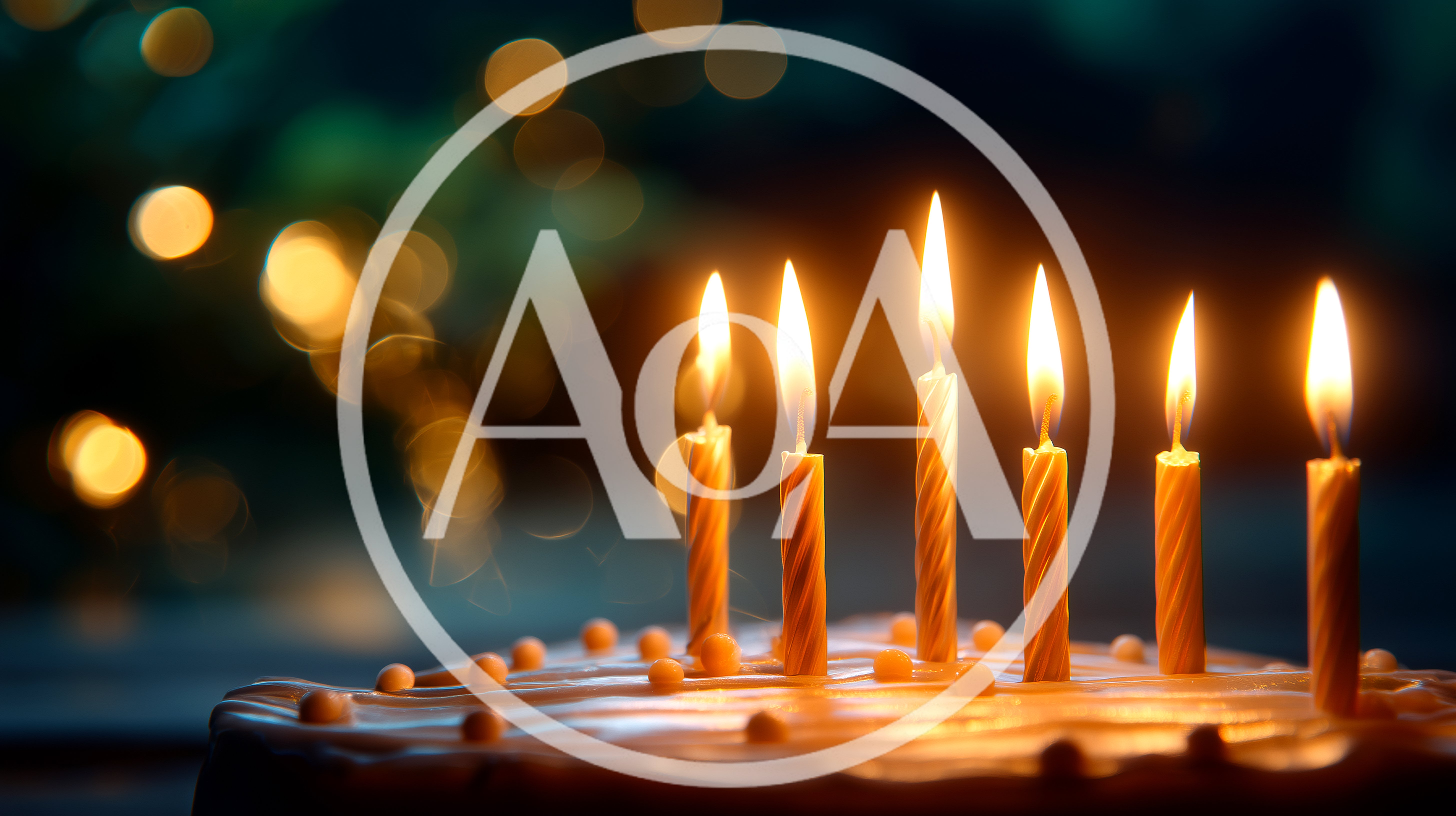 Six Lit Birthday Candles On A Frosted Cake
