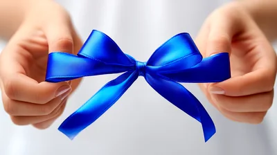 Hands Holding A Bright Blue Satin Ribbon Bow