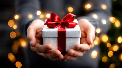 Person Holding A Gift Box With Red Ribbon