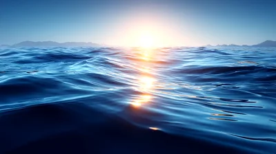 Calm Ocean Waves At Sunset With Distant Mountains