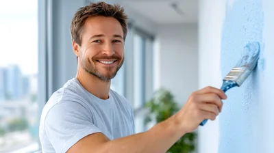 Smiling Man Painting Wall With Blue Paint