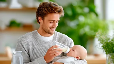 Young Father Feeding Baby With A Bottle