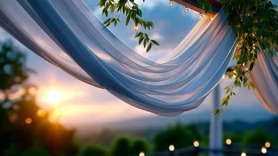 Wedding Arch Draped With White Fabric At Sunset