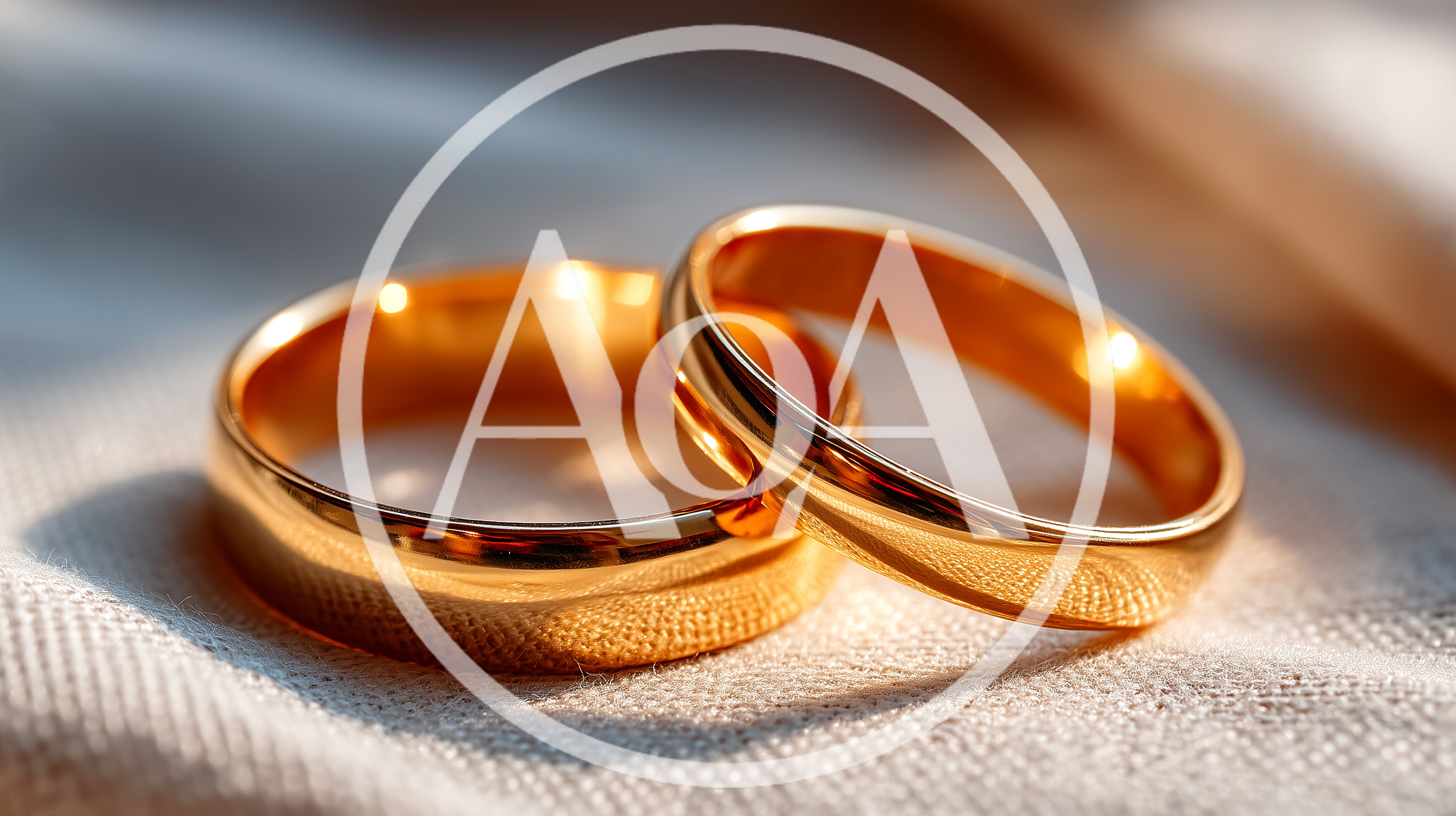 Two Golden Wedding Rings Resting On Textured Fabric