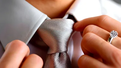 Close Up Of A Man Adjusting His Silver Tie
