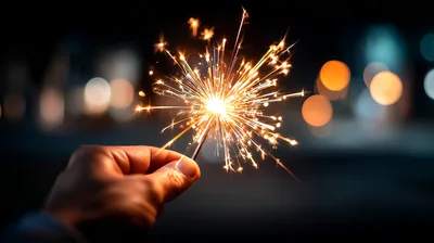 Hand Holding A Burning Sparkler At Night