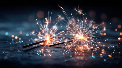 Two Burning Sparklers On A Dark Surface