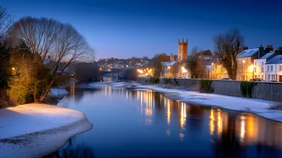 Snowy Riverbank At Twilight In A Historic Town