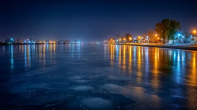 Nighttime View Of A Frozen River With City Lights