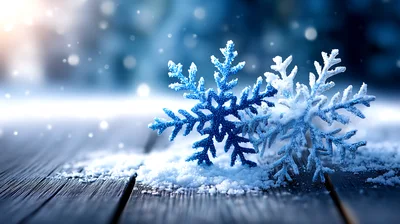 Two Decorative Snowflakes Resting On A Wooden Surface