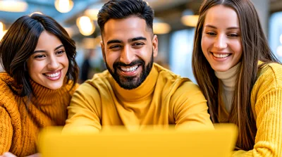 Three Diverse Friends Smiling While Using A Laptop