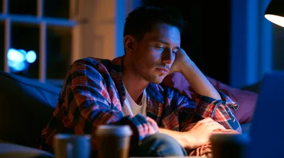 Tired Young Man Working Late On Laptop