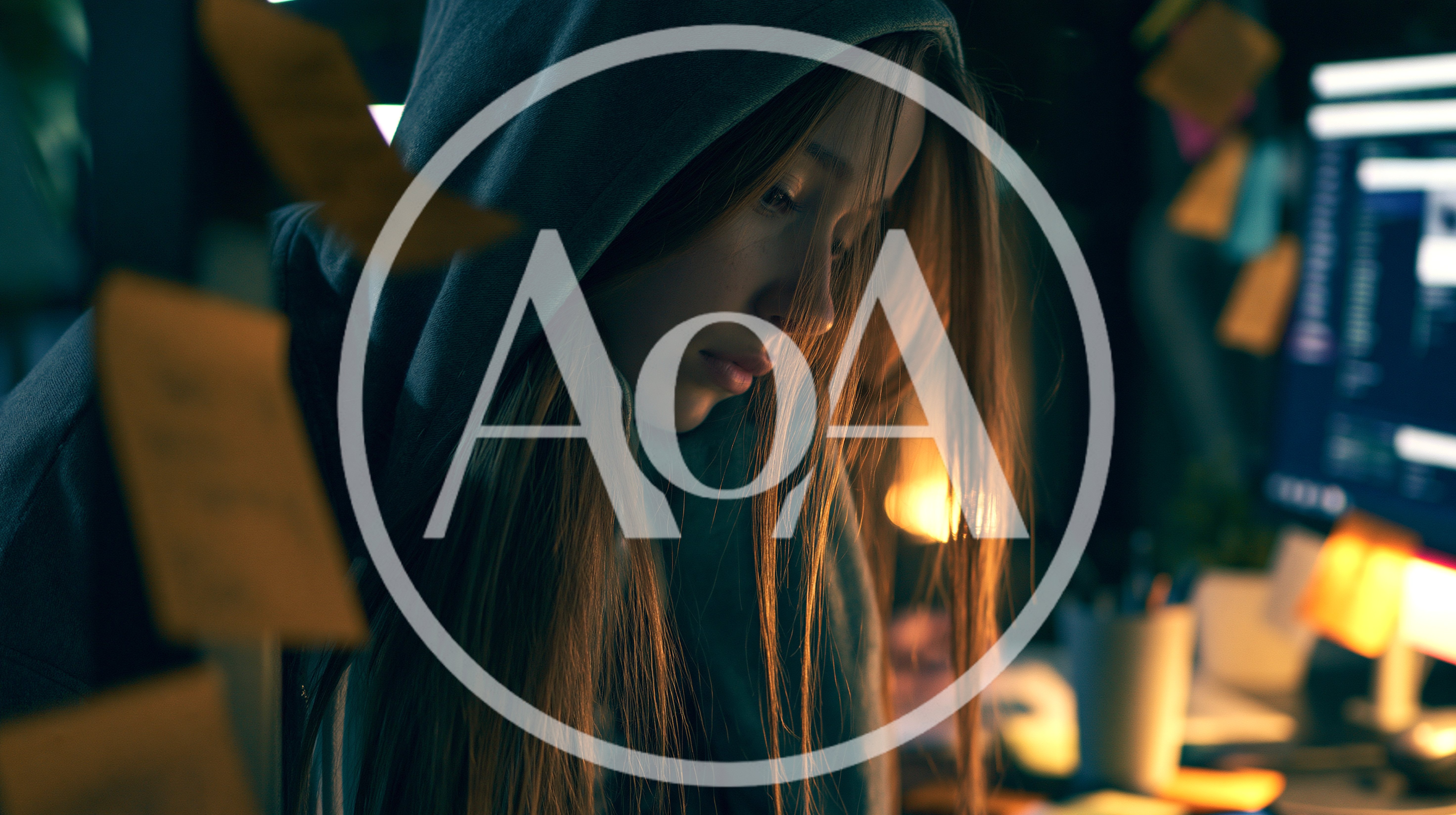 Young Woman Wearing Hoodie Working Late At Computer