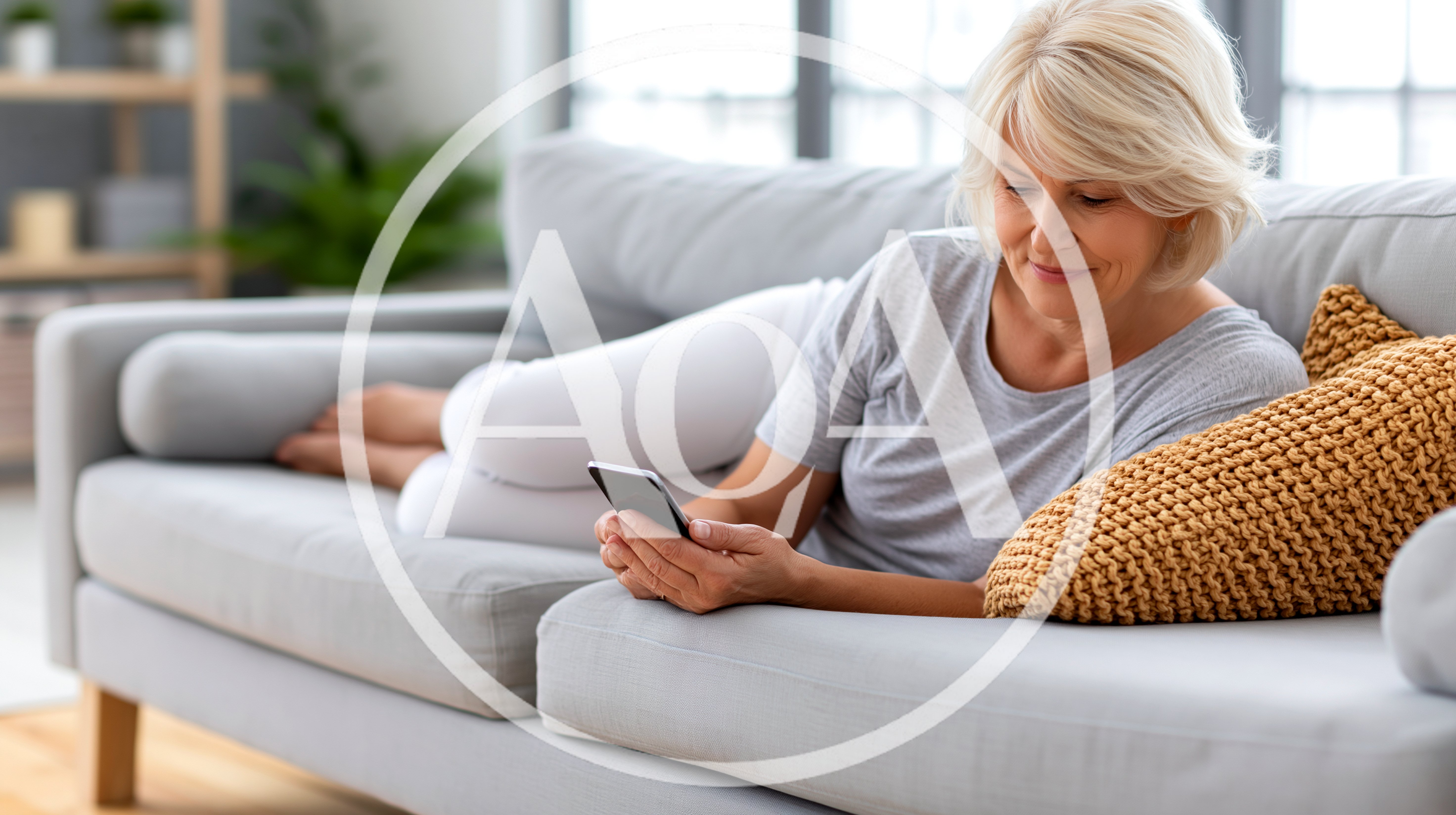 Senior Woman Relaxing On Sofa Using Smartphone