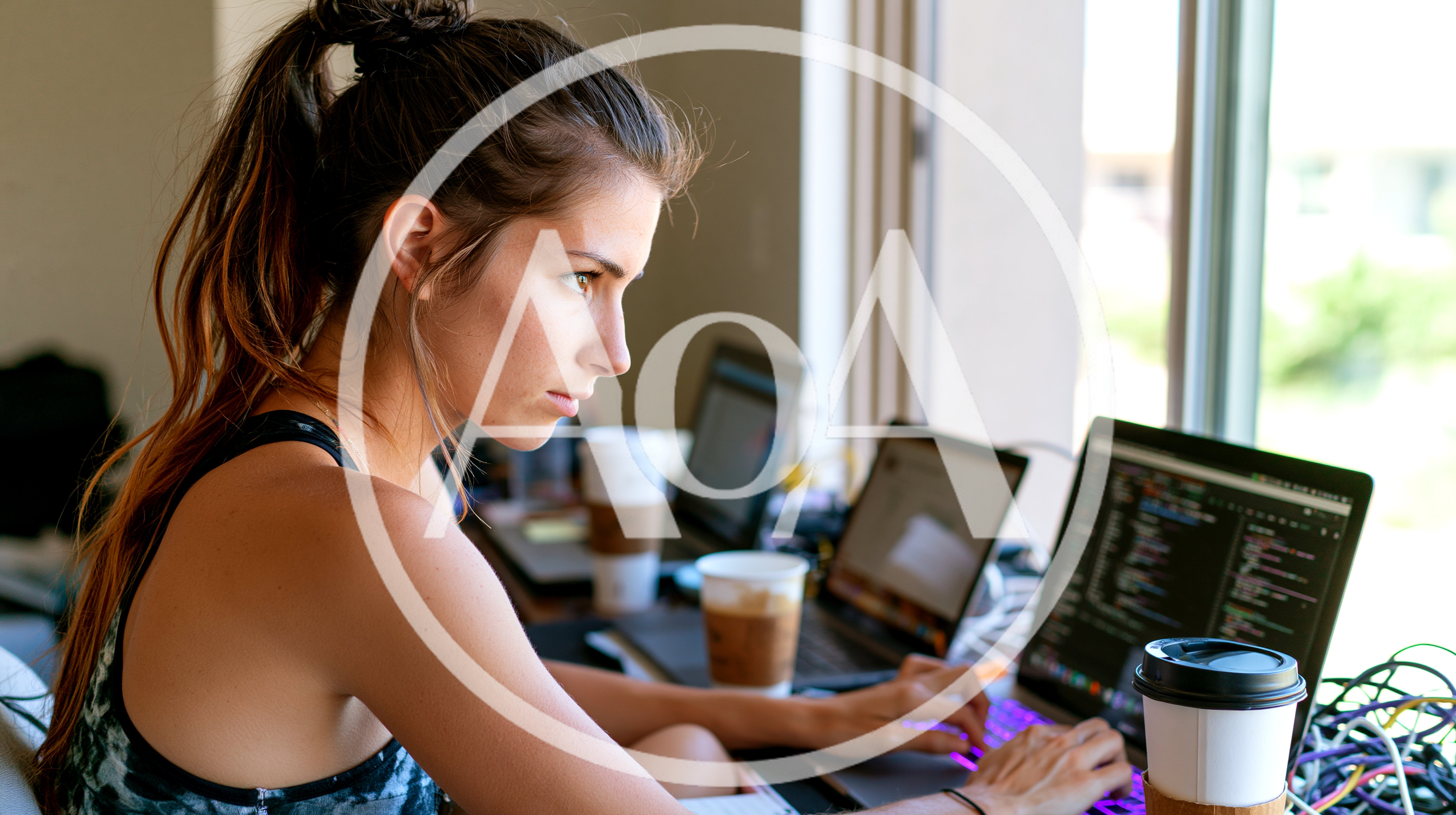 Young Female Software Developer Coding On Multiple Laptops