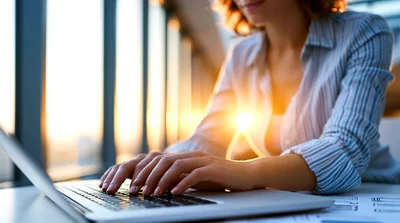Businesswoman Typing On Laptop In Sunny Office