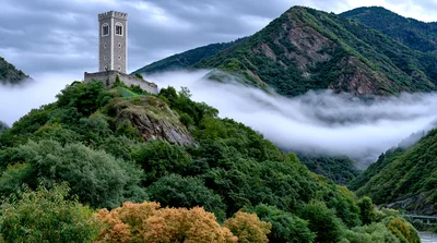 Medieval Stone Tower Atop A Lush Mountain Peak