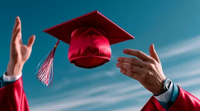Graduate Throwing Red Graduation Cap Into The Sky