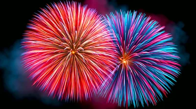 Vibrant Red And Blue Fireworks Bursting In Night Sky