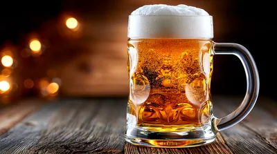 Glass Beer Mug With Foam On Wooden Table