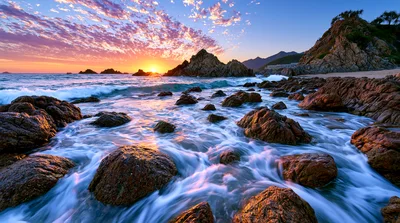 Rocky Coastline At Sunset With Crashing Waves