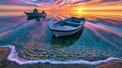 Two Small Boats Resting On Calm Shallow Water At Sunset