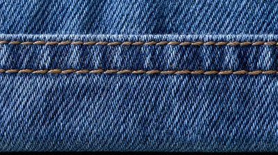 Close Up Of Blue Denim Fabric With Stitching