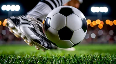 Soccer Player Kicking Ball On Grass Field
