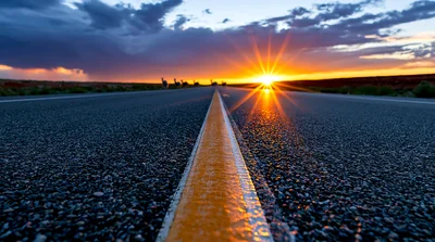 Empty Asphalt Road Leading Toward A Bright Sunset