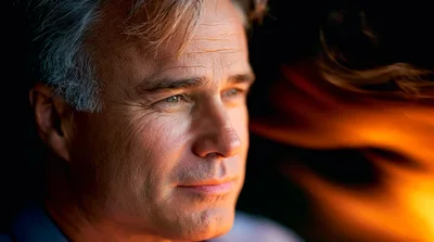 Thoughtful Mature Man Looking Away Near Firelight
