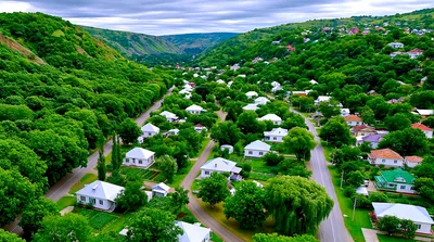 Aerial View Of A Village Nestled In A Green Valley