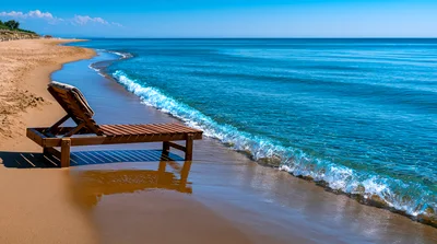 Wooden Lounge Chair On A Sunny Sandy Beach