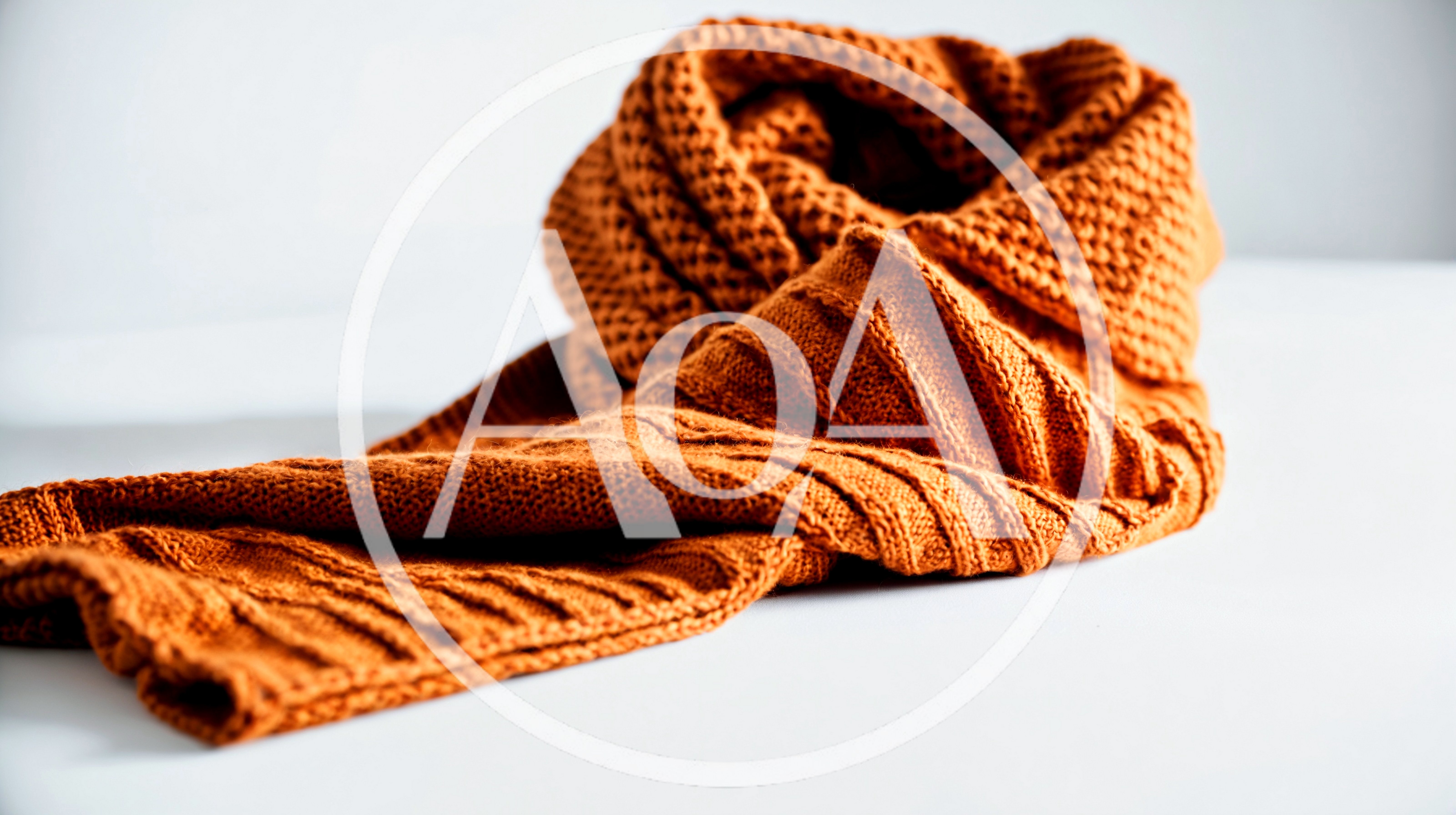 Orange Knitted Scarf Resting On White Surface