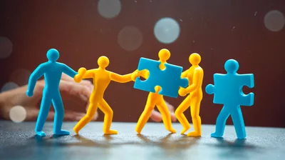 Plastic Figurines Connecting Blue Puzzle Pieces Together
